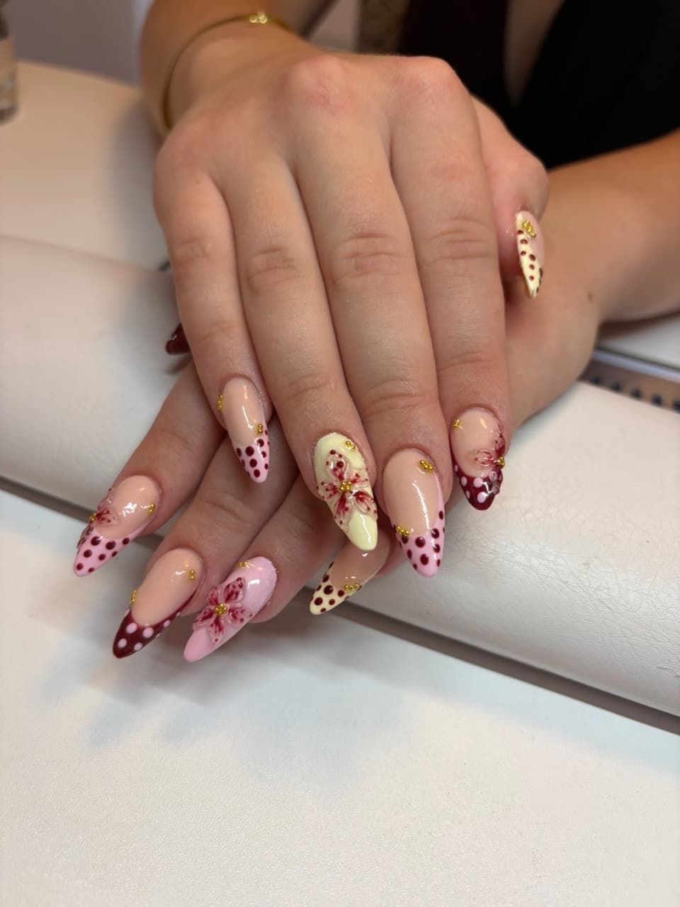 Verspielte Nail Art mit Blüten, Punkten und goldenen Details